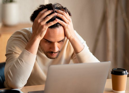 Мужчина сидит склонив голову в руки